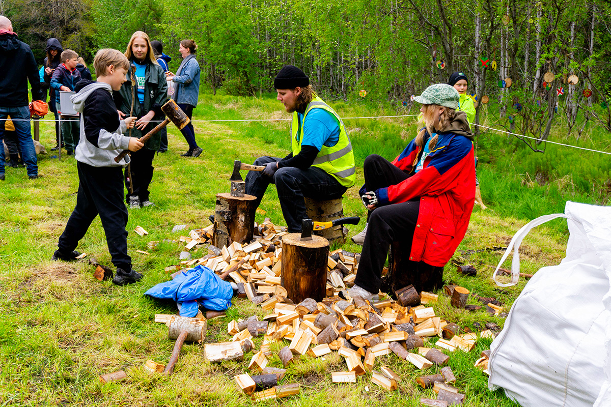Young attendees splitting firewood