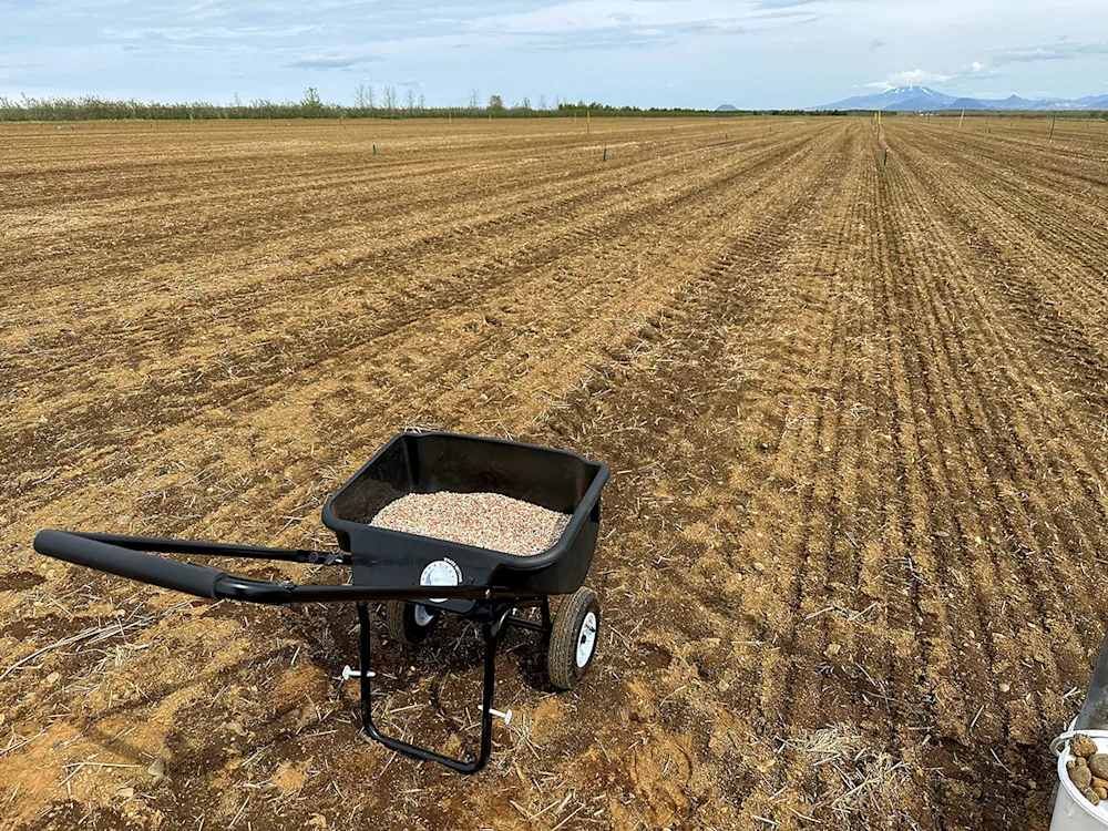Fertiliser distributor in an experimental plot. Volcano Hekla at right in the far distance. Photo: Magnús H. Jóhannsson