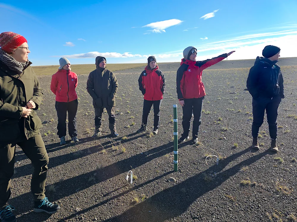 Salbjörg Matthíasdóttir, Regional Representative and Project Manager for Hólasandur, Collaborative Projects, and Organic Fertilisers in Northeastern Iceland, showing an area on Hólasandur where the application of sludge to barren sand resulted in the emergence of vegetation from dormant seeds within the sand. Photo credits: Pétur Halldórsson.