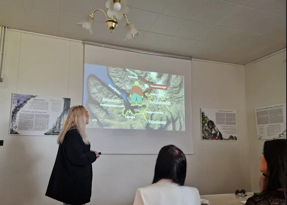 Kona heldur kynningu og sýnir glæru á vegg.