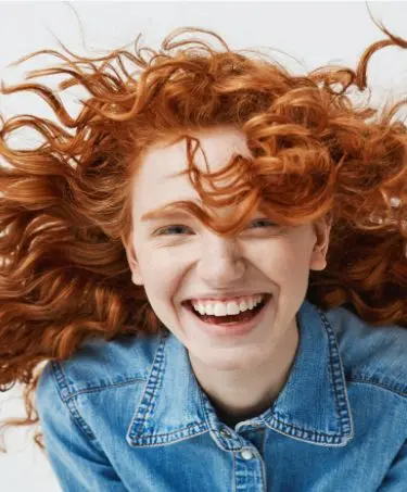 Smiling model with curly ginger hair