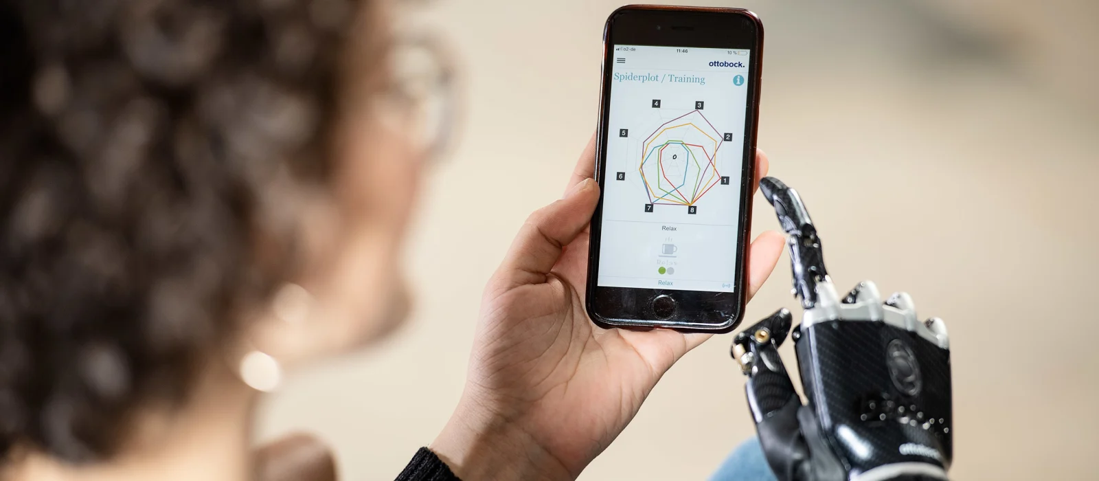 Ragazza con mano bebionic controlla gli schemi di movimento Myo Plus sul suo smartphone