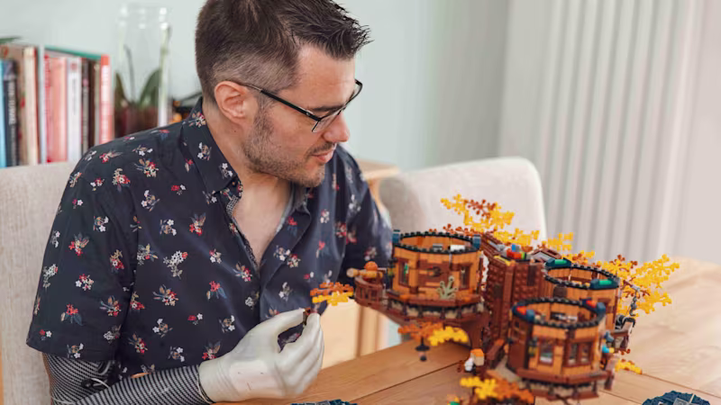 Man building with Lego using his Michelangelo multi-grip prosthetic hand from Ottobock.