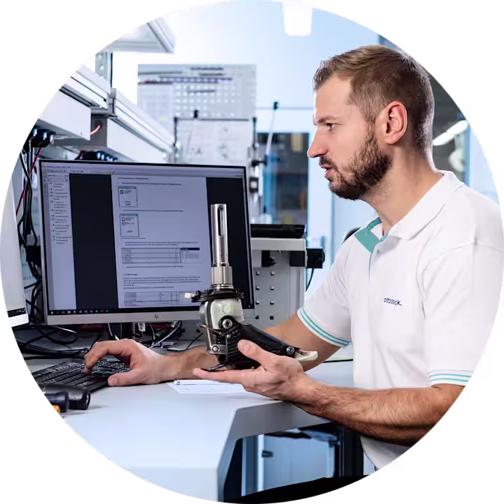 Product support technician holding a prosthetic foot looking up specifications.