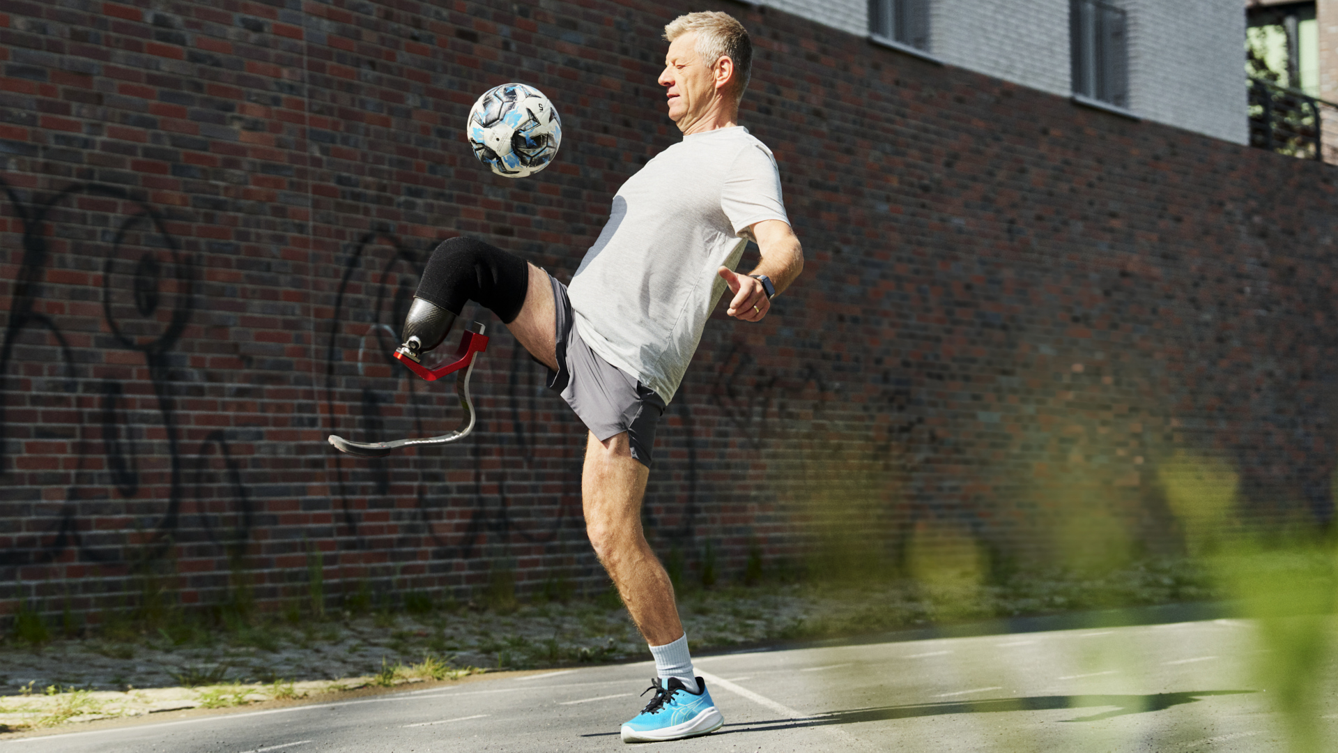 An elder prosthetic leg user playing soccer