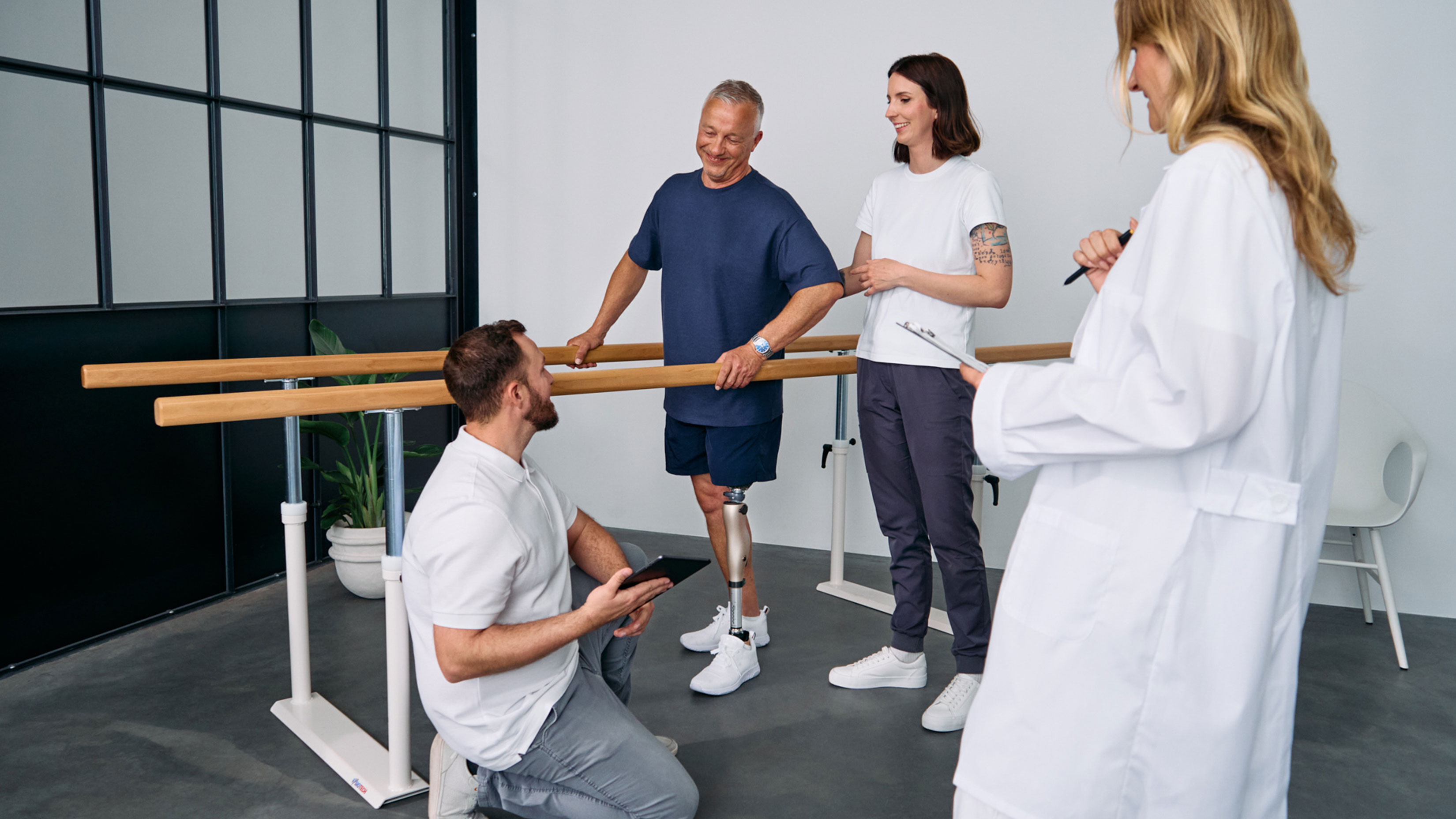 Un amputado por encima de la rodilla probando la rodilla controlada por microprocesador Kenevo de Ottobock en un centro de ortesis y tratamiento protésico