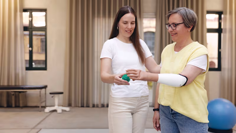 Eine Therapeutin und eine Armprothesenträgerin trainieren gemeinsam die Benutzung der Armprothese speedhand von Ottobock.