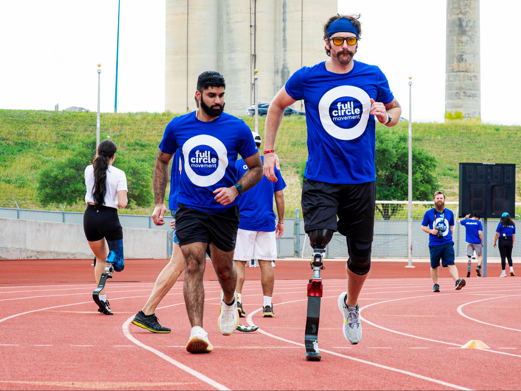 Les participants aux différences de membres courent sur un terrain extérieur pendant l’événement Full Circle Movement