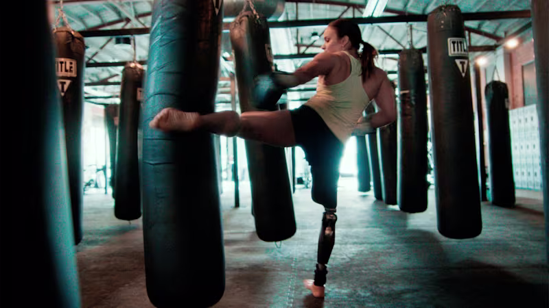 Amy stands on her C-Leg 4 as she kicks a heavy bag with her other leg