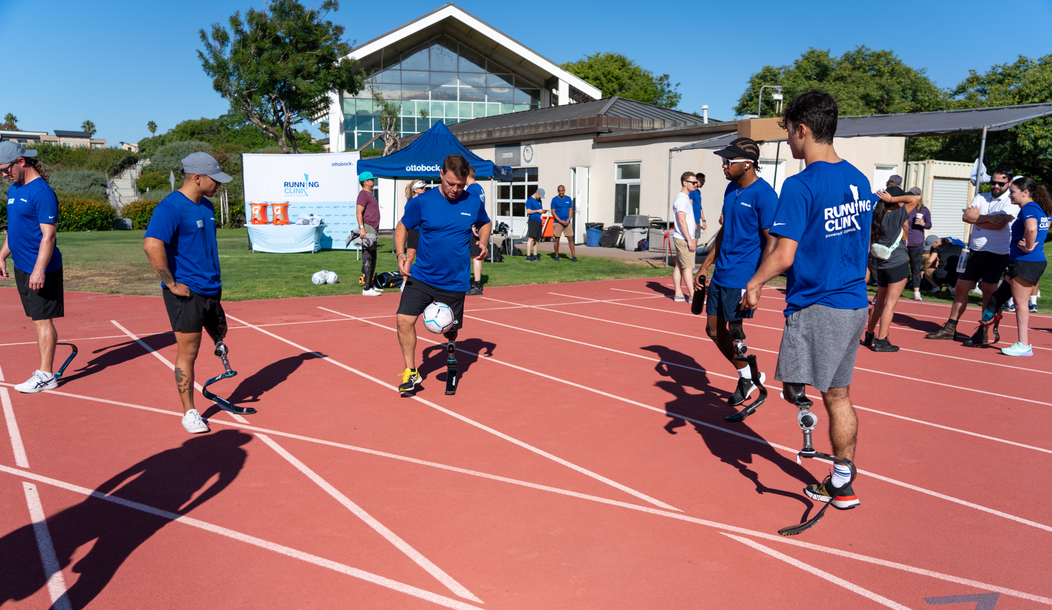 Heinrich Popow and Running Clinic attendants playfully kicking a soccer ball