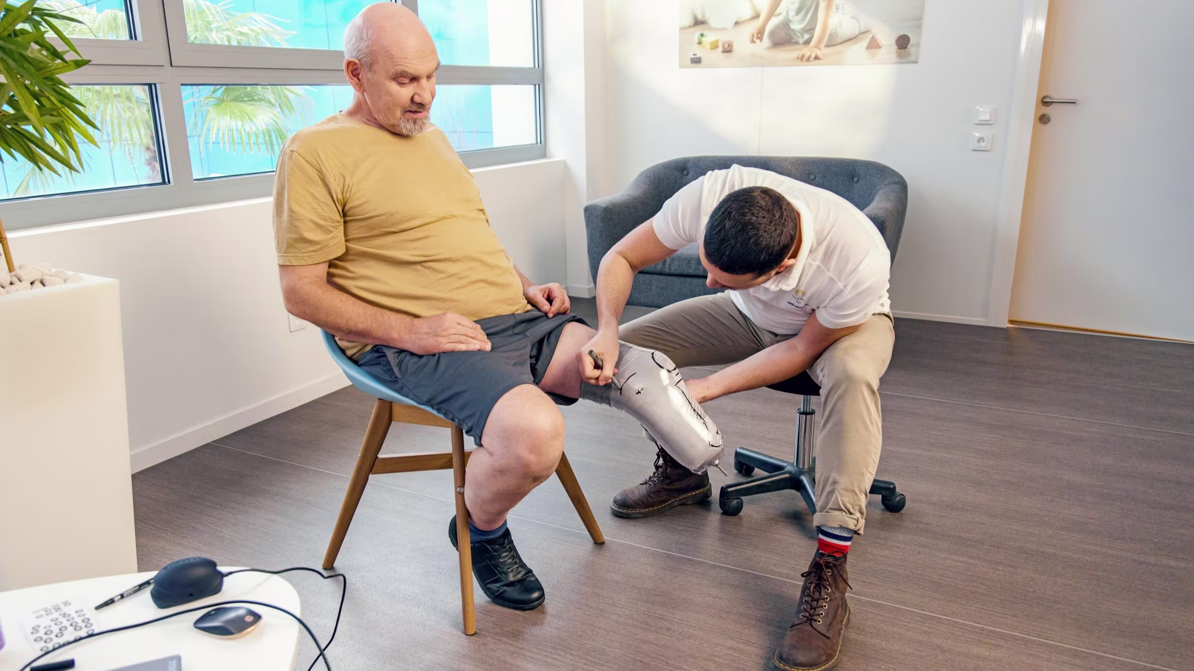 A Certified Prosthetist assisting a patient with his prosthetic suspension system