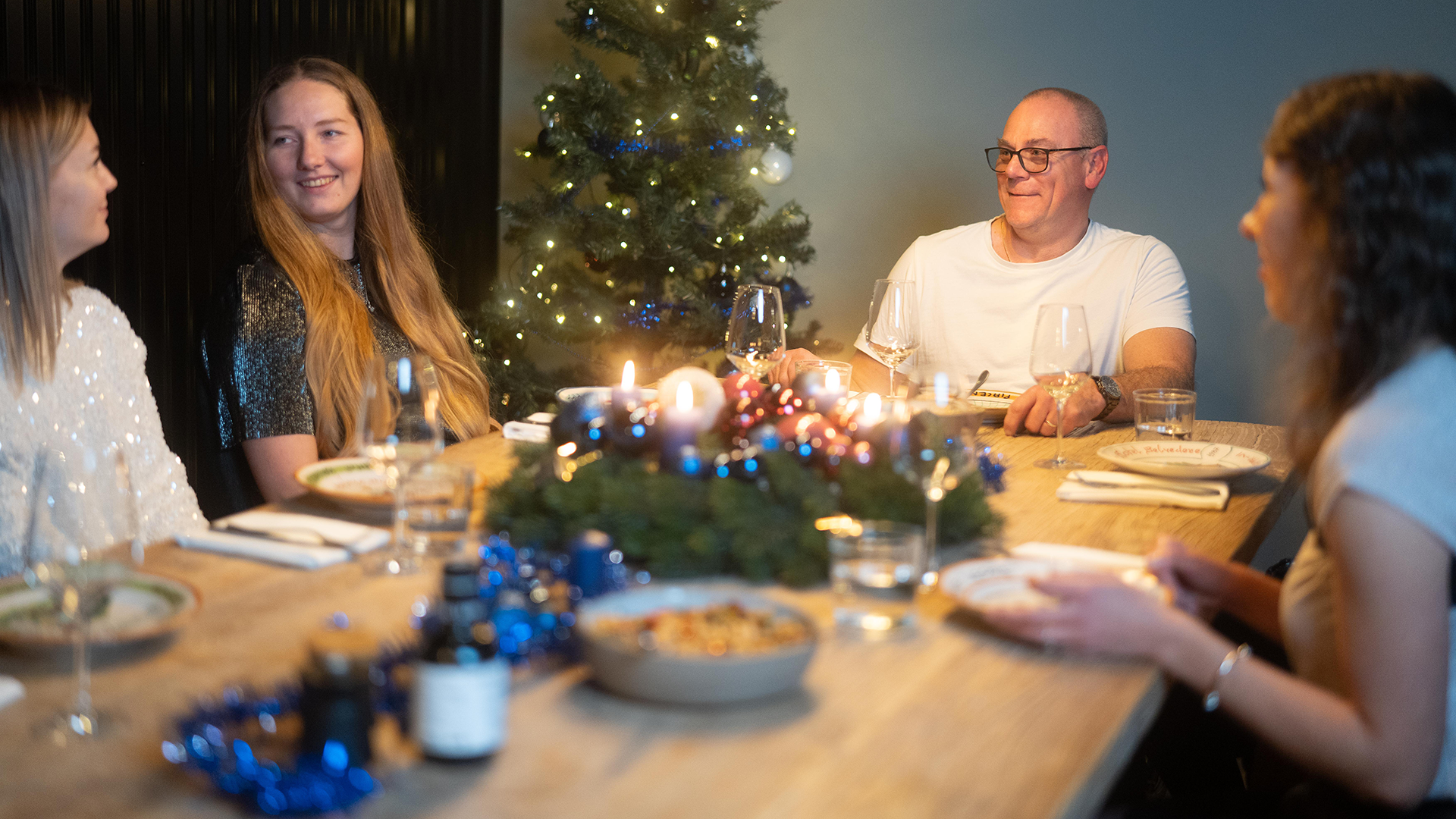 Ottobock AnwenderInnen bei einem gemeinsamen Essen vor einem Weihnachtsbaum.
