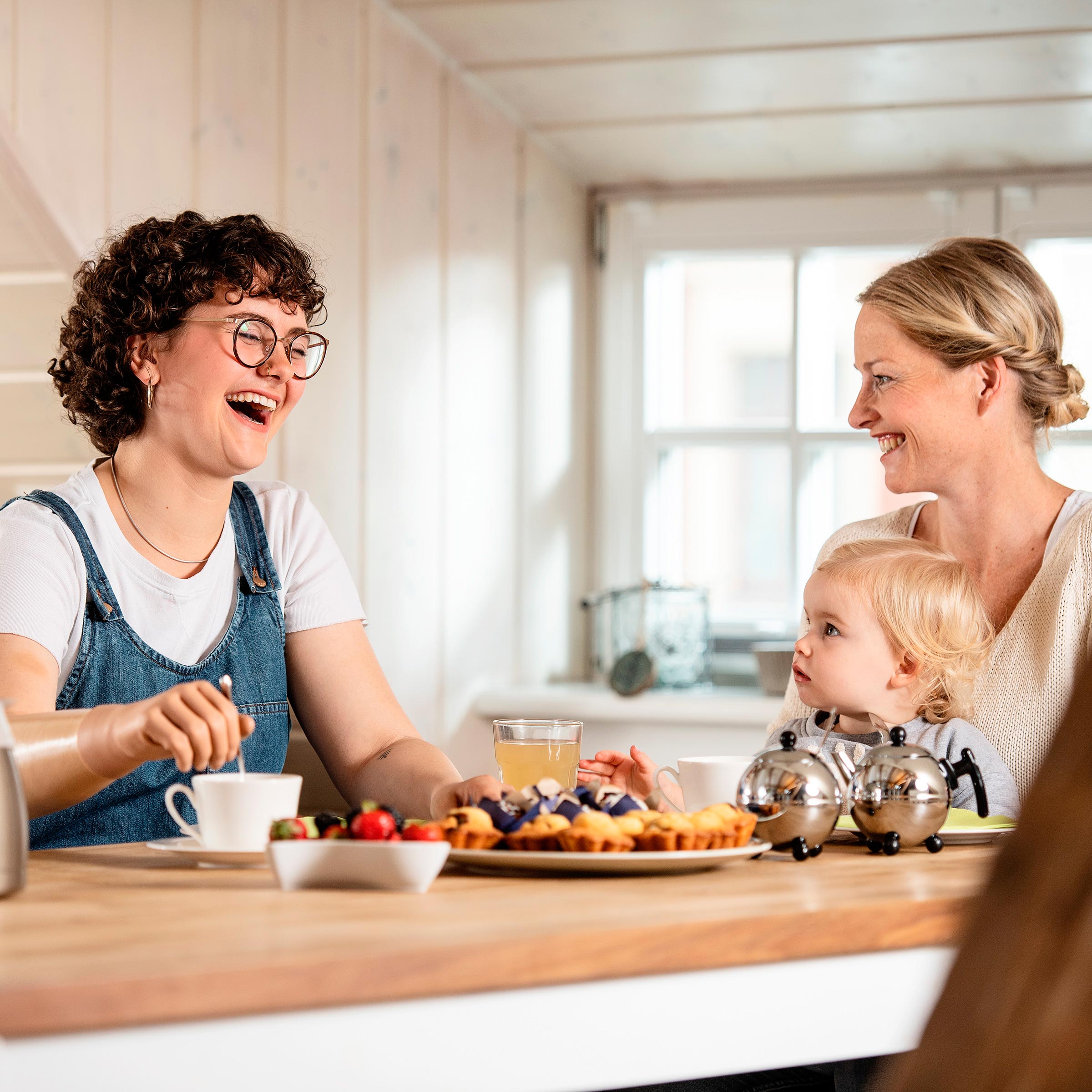Ragazza con gli occhiali facendo uso di una mano protesica Ottobock a colazione con la famiglia.