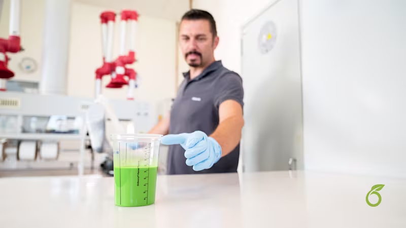 Man in an O&P Workshop reaching out to a cup of Ottobock OrthoEpox Greenline in front of him