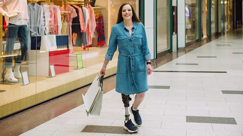 A leg amputee strolls through an indoor mall sporting an Ottobock bionic leg