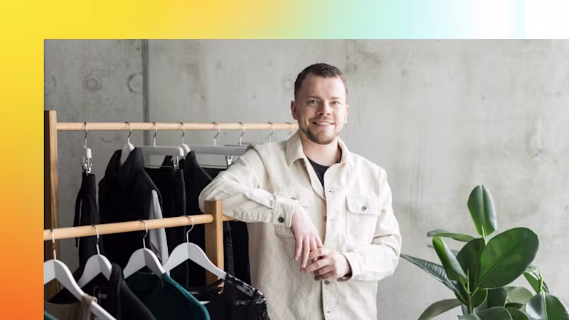 Zalando designer Philipp Hammermeister leaning against a clothes rack, looking directly into the camera.