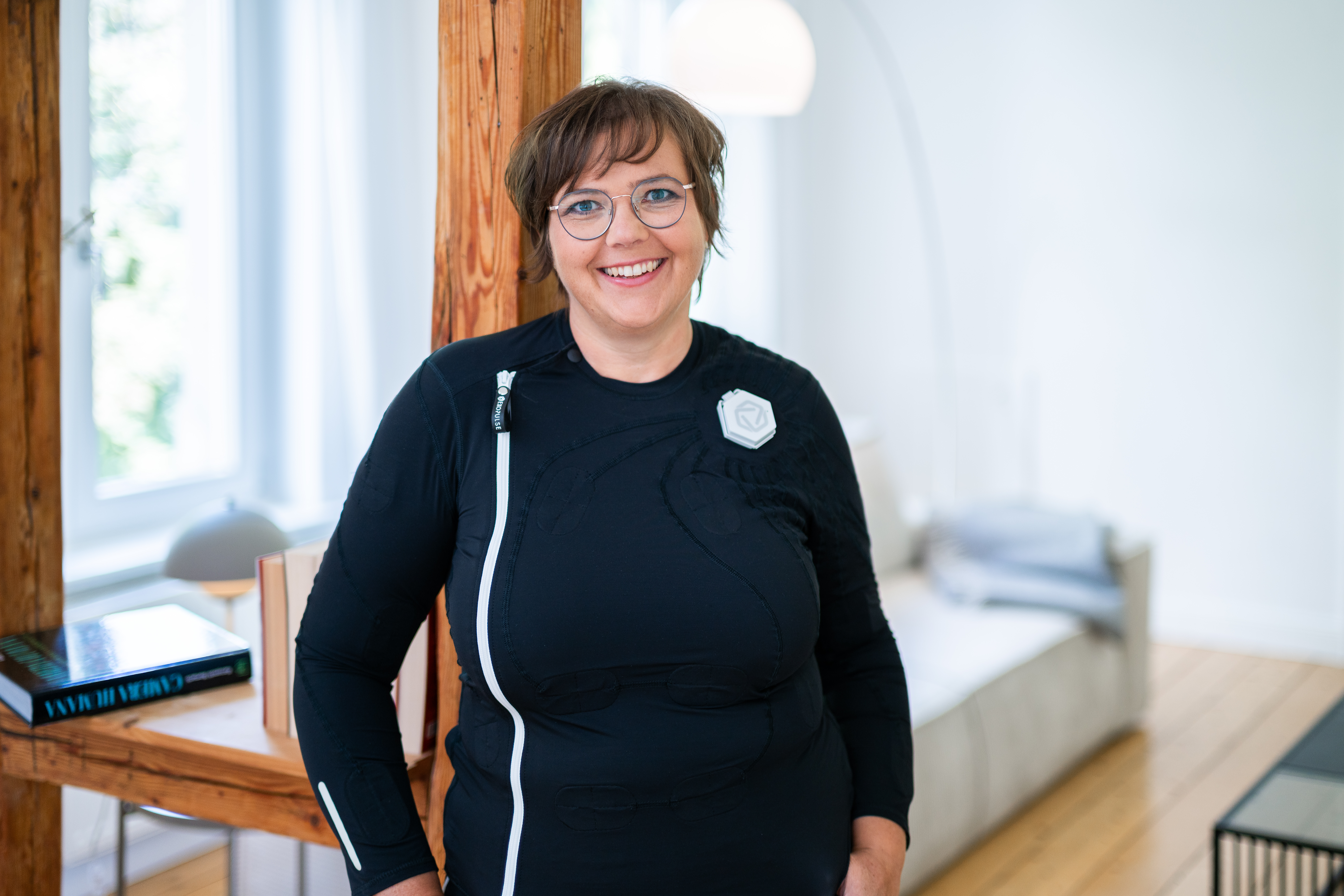 Ottobock Exopulse Mollii Suit User Elisa with young girl playing Scrabble in living room while smiling