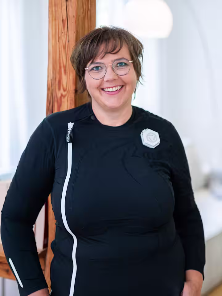 Ottobock Exopulse Mollii Suit User Elisa with young girl playing Scrabble in living room while smiling