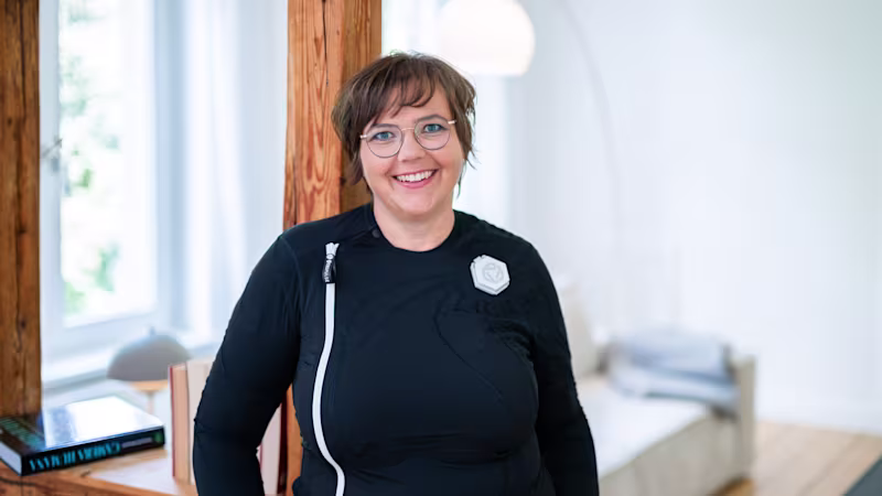 Ottobock Exopulse Mollii Suit User Elisa with young girl playing Scrabble in living room while smiling