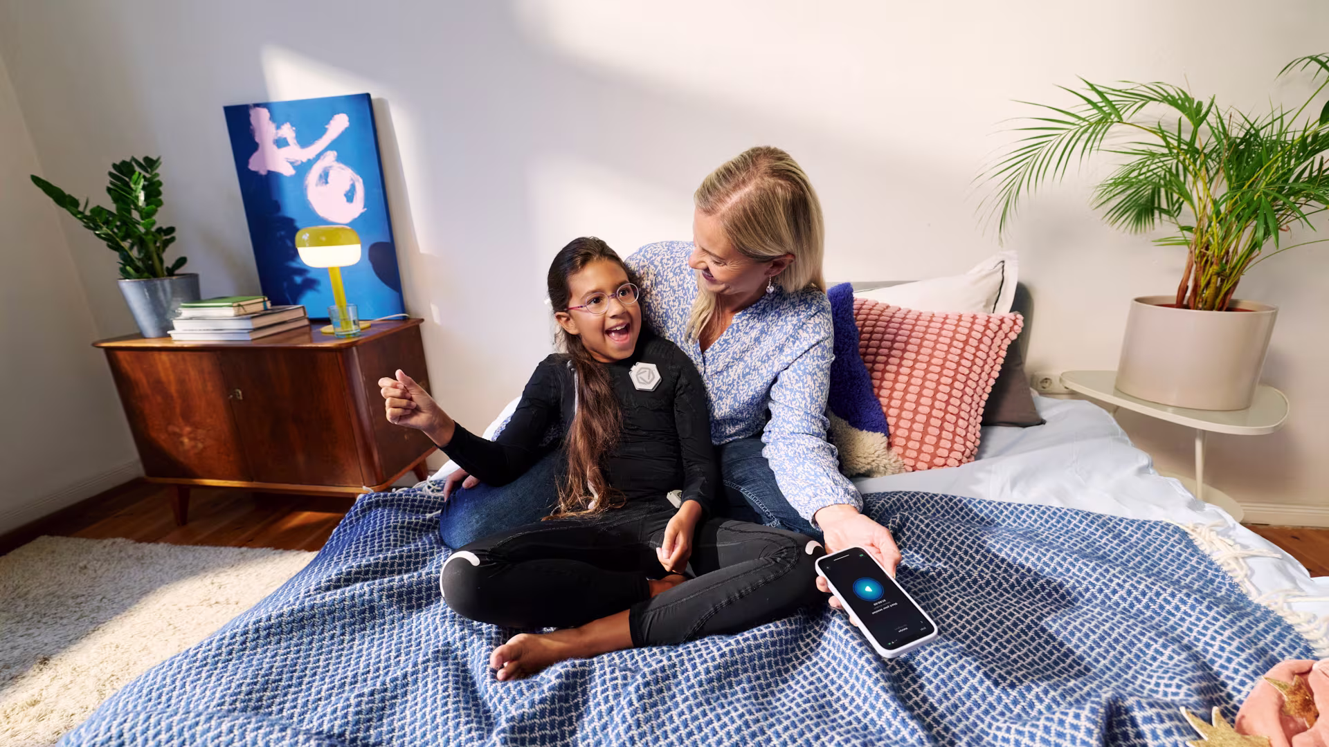 Child wearing the exopulse suit for children using the mobile app at home