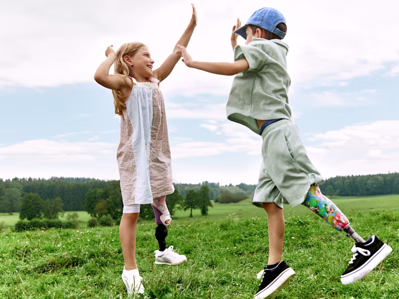 Two children with Ottobock leg prostheses spending time outdoors.