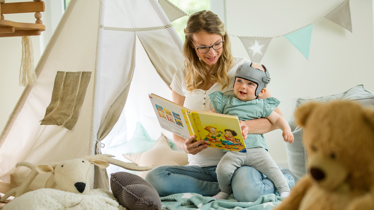 Une mère lit un livre pour enfants à son enfant qui porte le bracelet MyCRO.