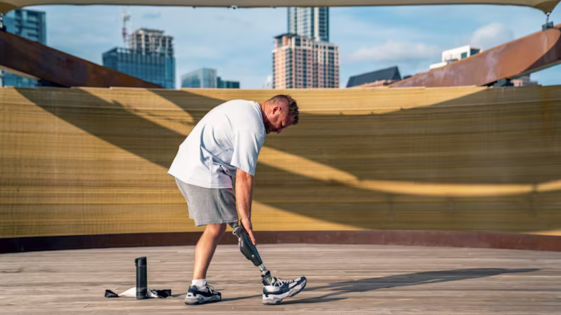 C‑Leg user Chance exercises in a modern environment with a city skyline in the background.