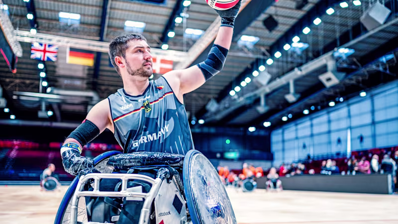 A player from the German national team’s wheelchair rugby team plays basketball indoors.