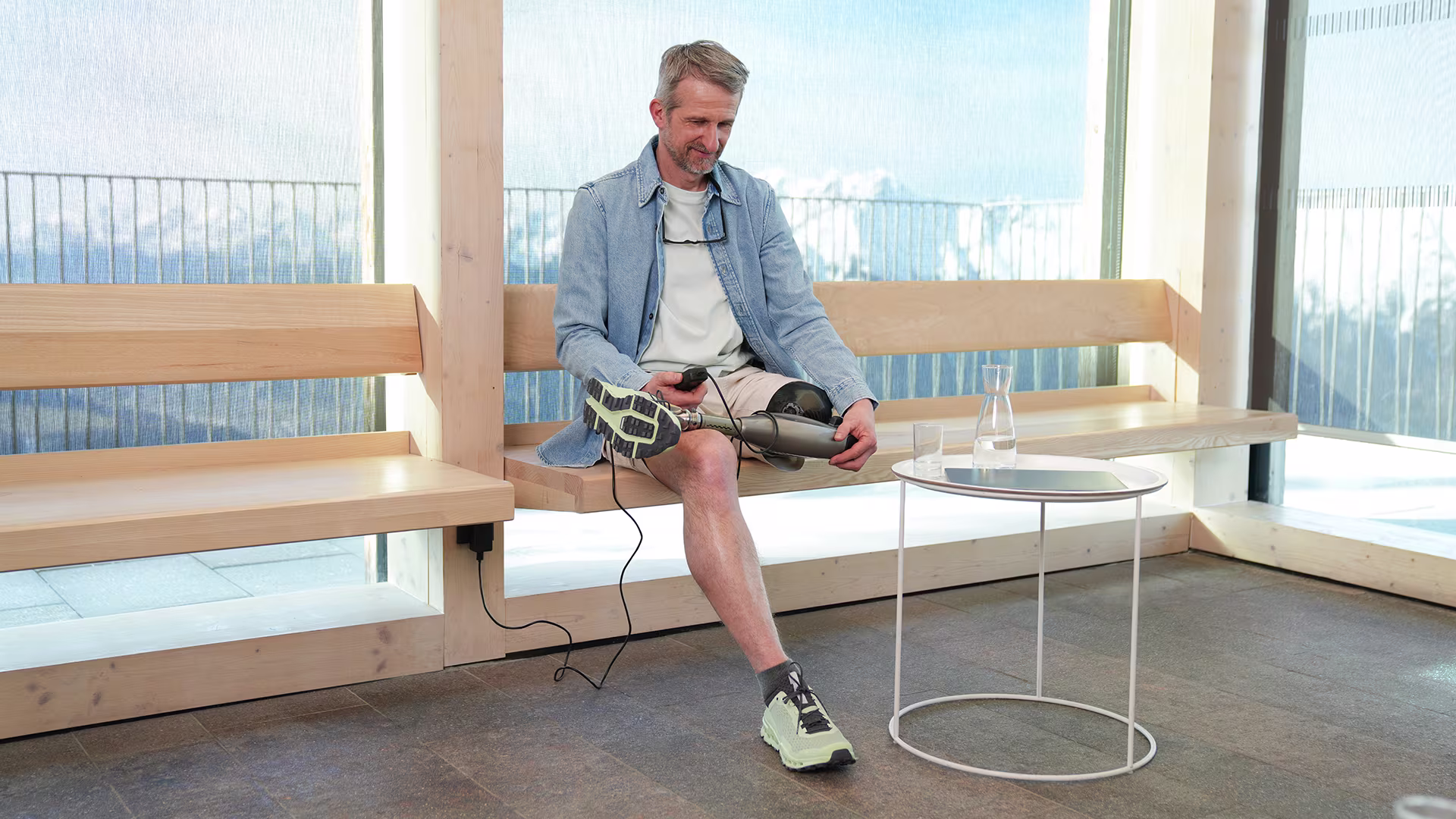 Prosthetic leg user sitting with an Ottobock Rotation adapter on the prosthesis.