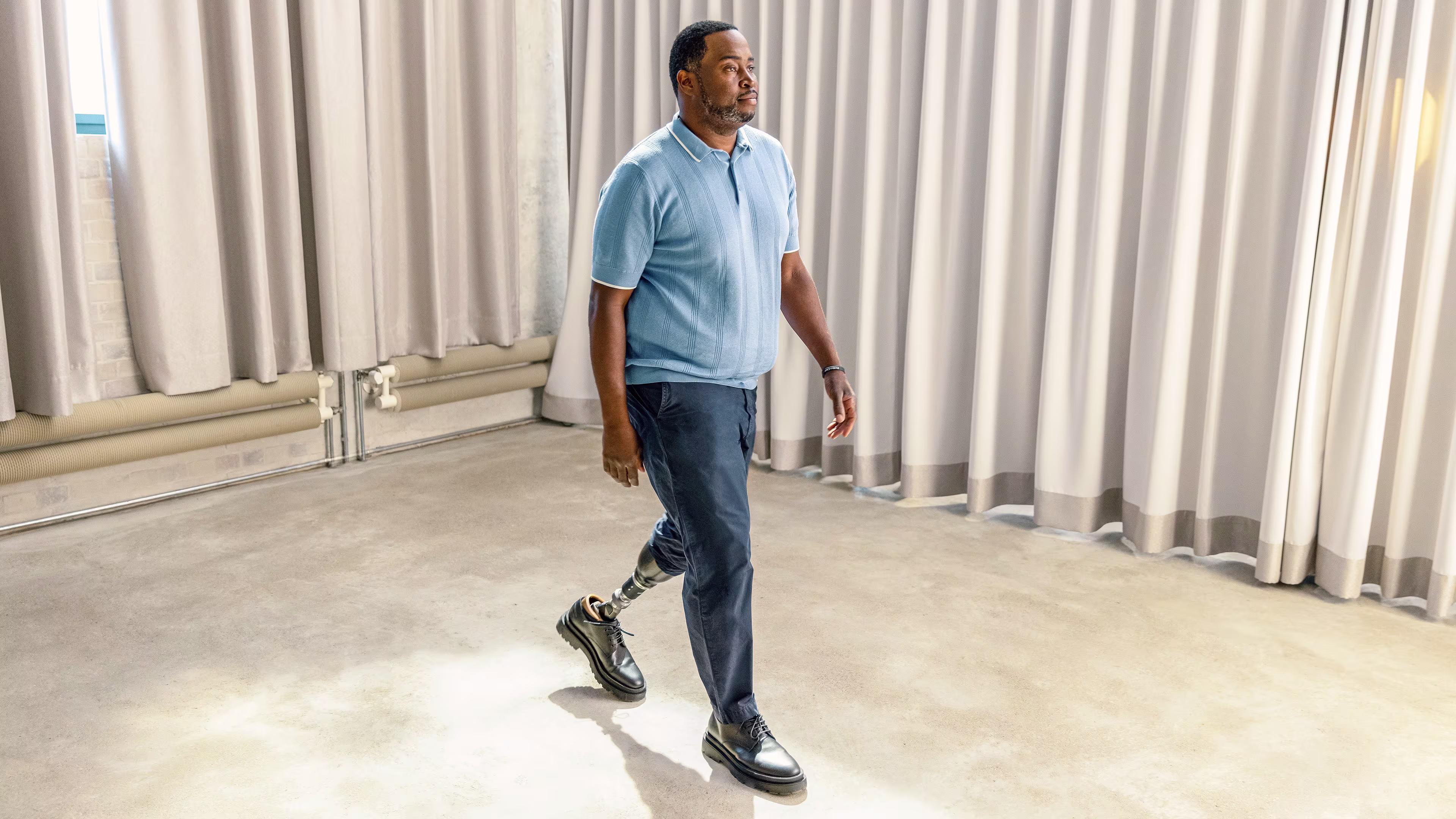 A man with the Taleo Adapt hydraulic prosthetic foot from Ottobock is walking across a room