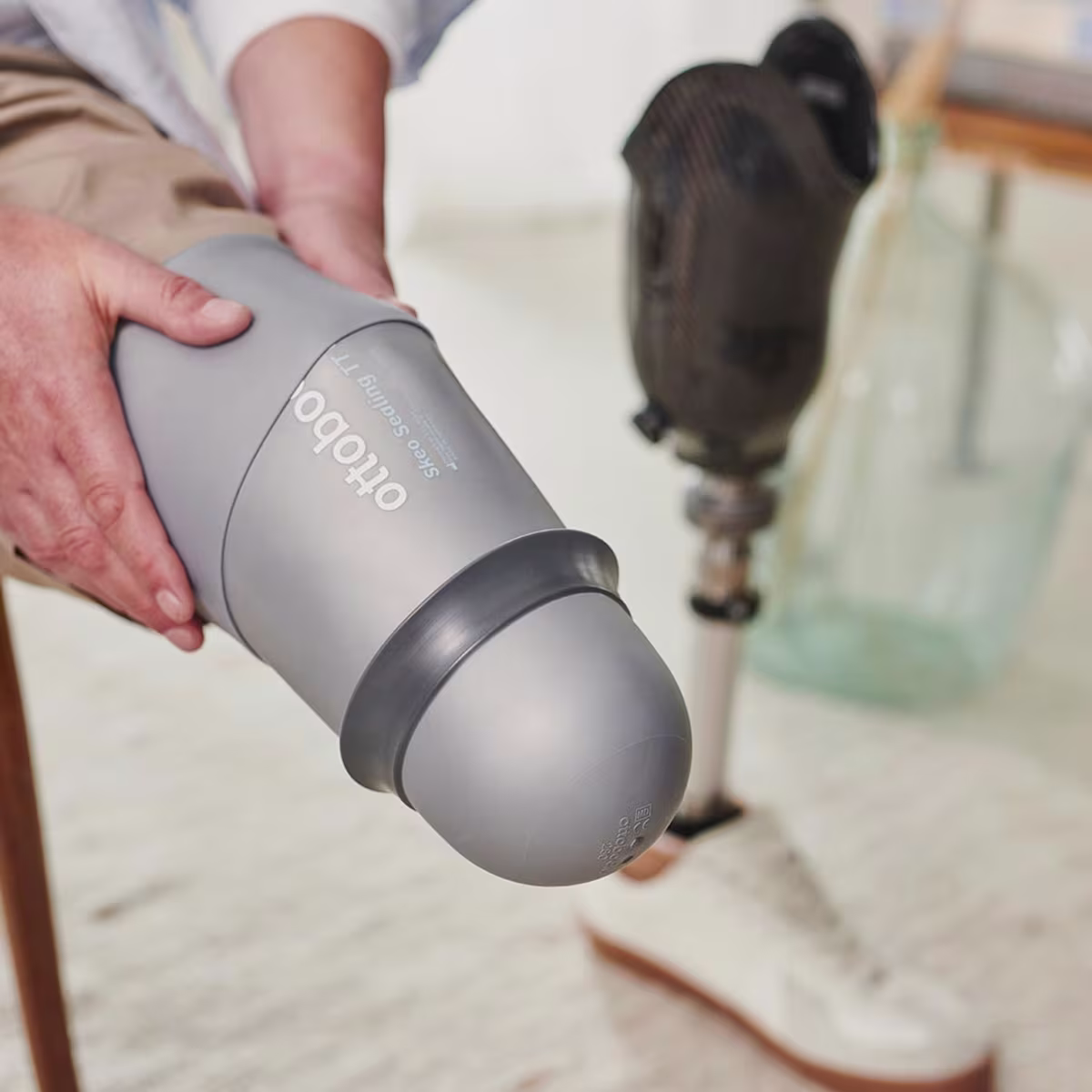 A man with a transtibial amputation is donning his Skeo Sealing Liner TT from Ottobock