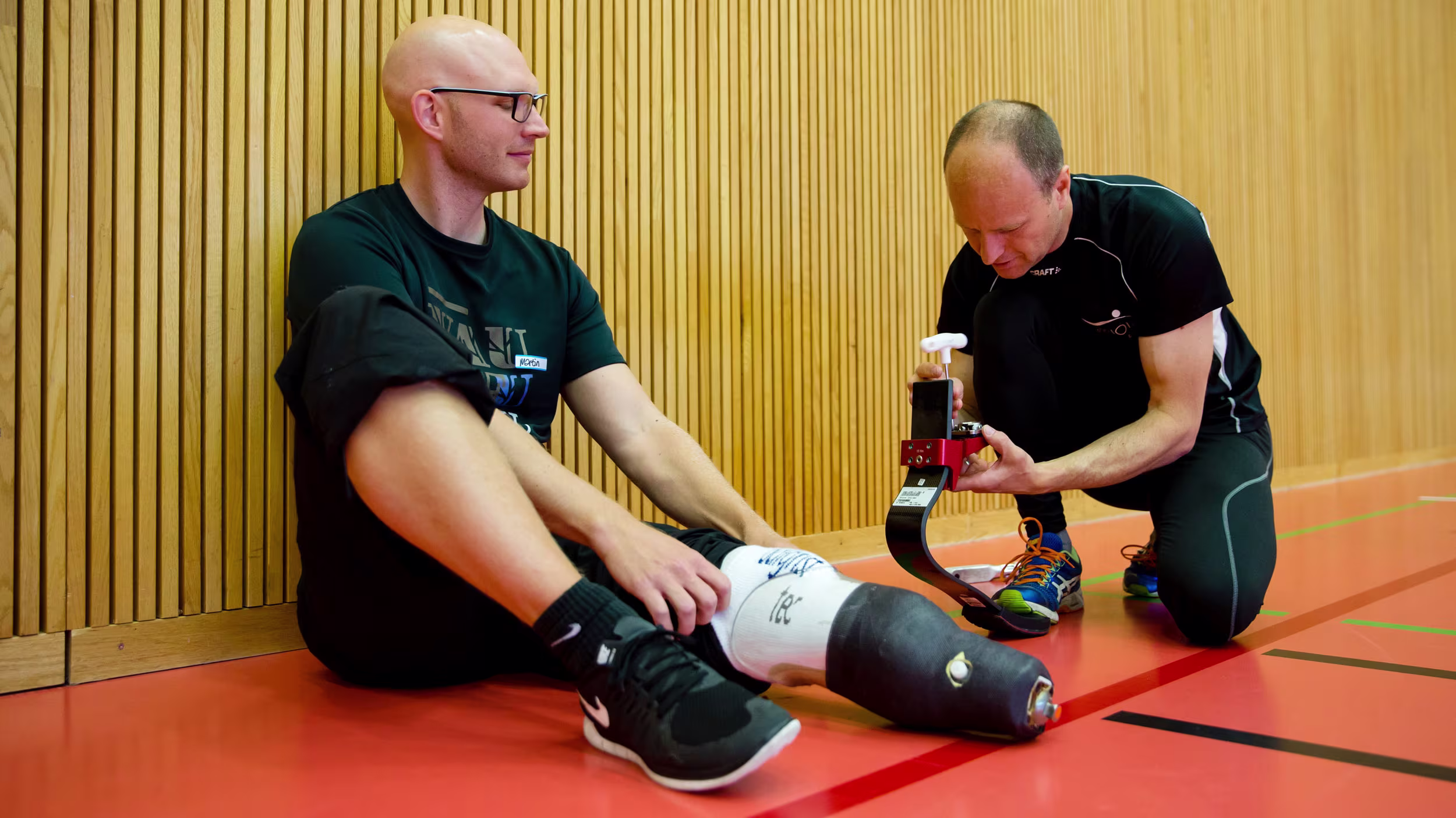 A prosthetist helping an amputee adjust their prosthetic running blade