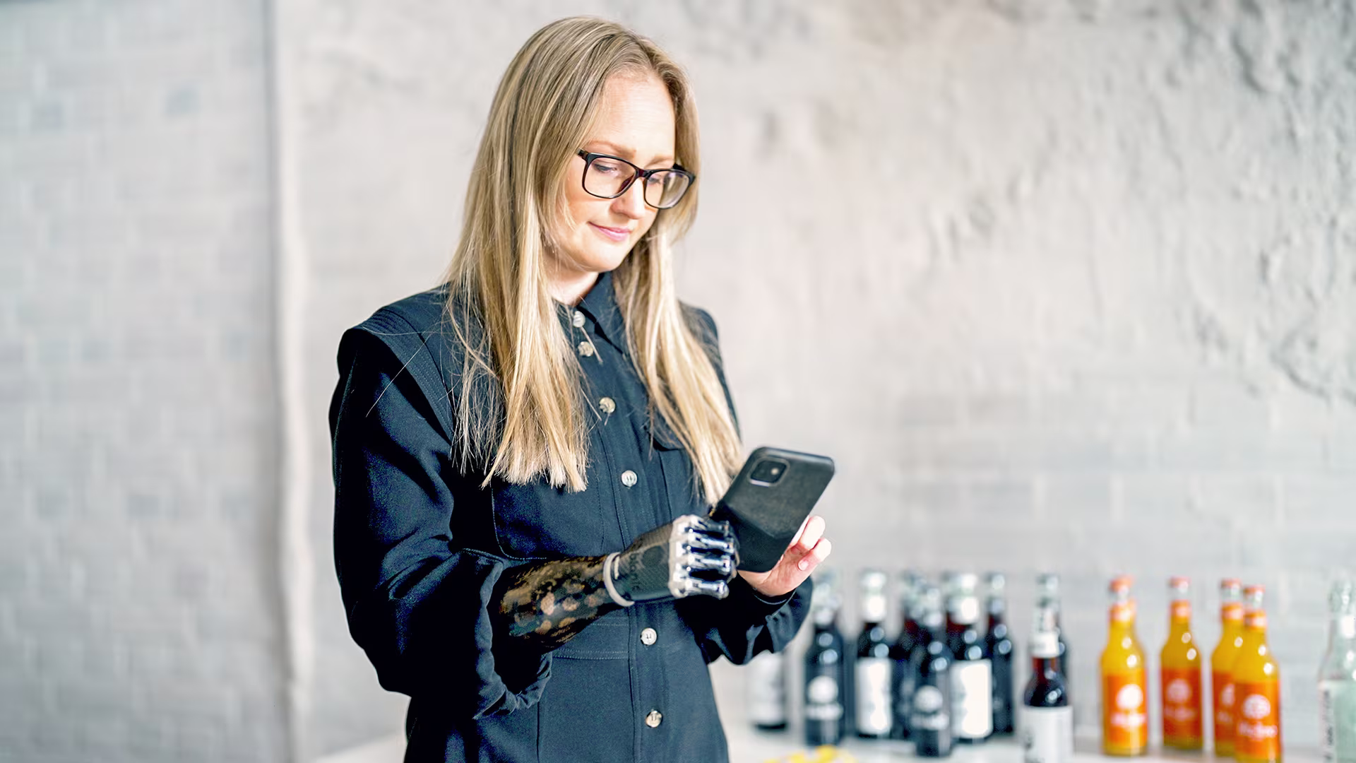 Ottobock prosthetic hand user checking her smartphone.