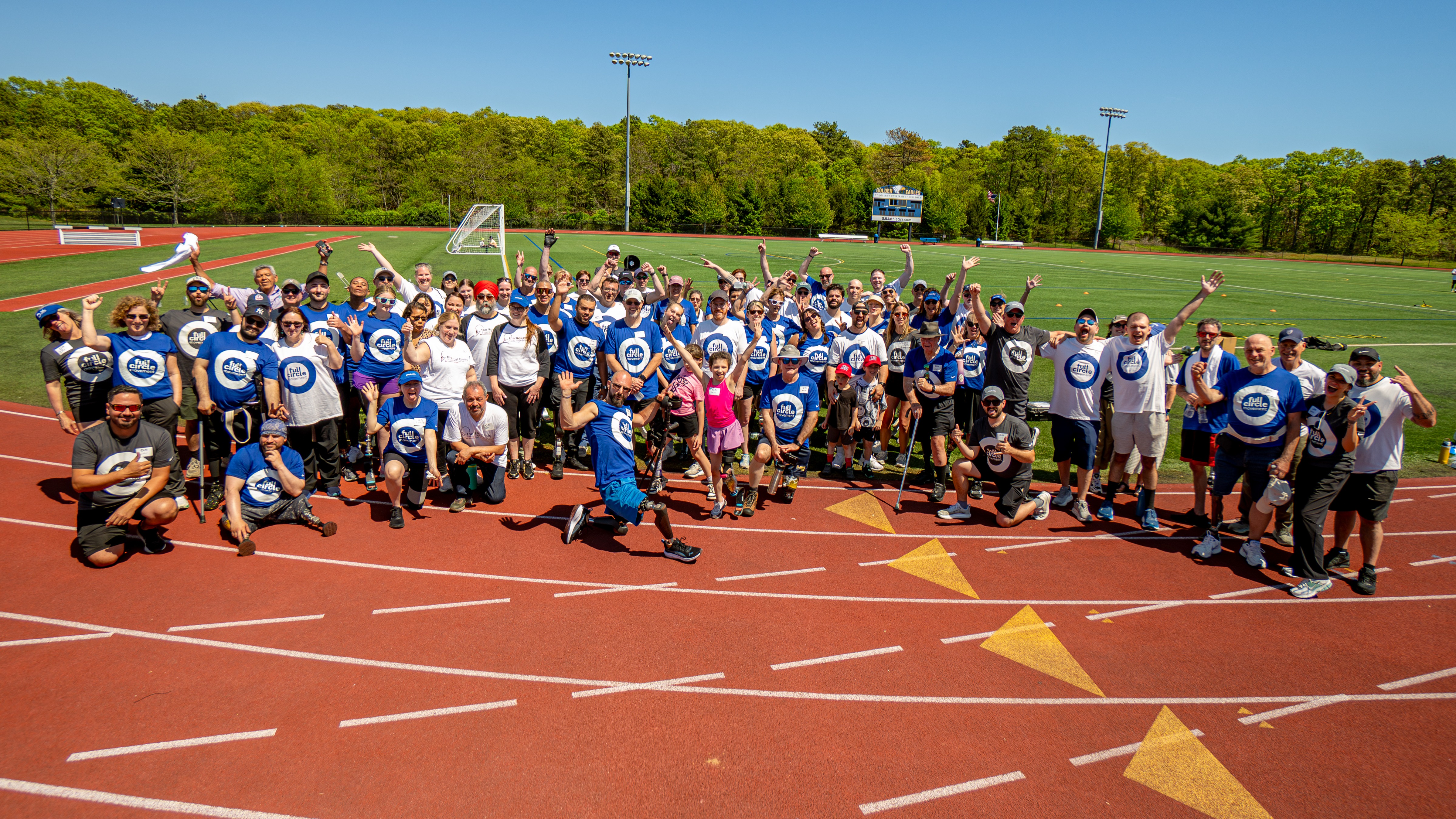 A large group of Full Circle Movement participants, volunteers, and Certified Orthotists Prosthetists gather for a photo
