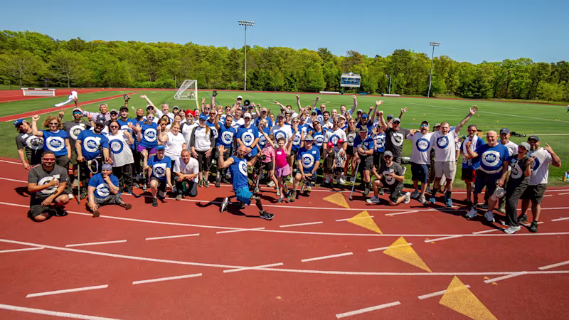 A large group of Full Circle Movement participants, volunteers, and Certified Orthotists Prosthetists gather for a photo