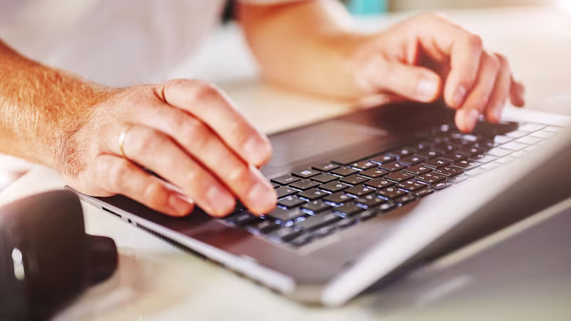 Someone typing on their laptop