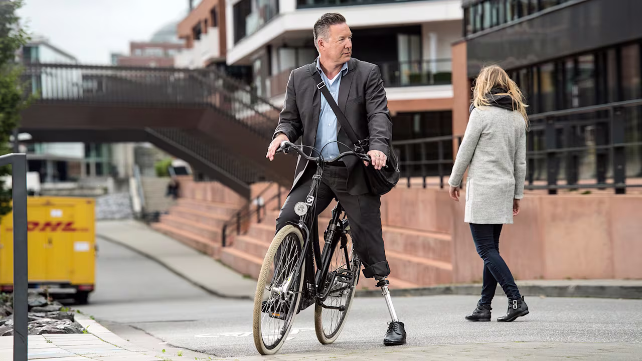 A lower limb amputee riding a bike with his prosthetic leg and Triton Side Flex by Ottobock