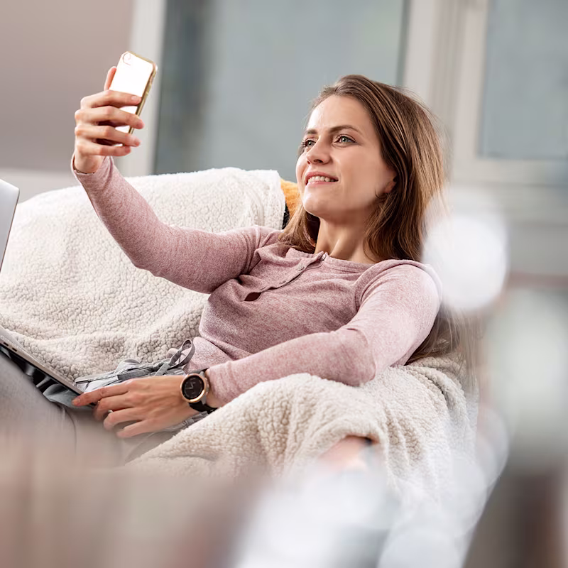 Réka mit Smartphone auf dem Sofa