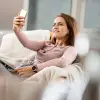 Réka mit Smartphone auf dem Sofa