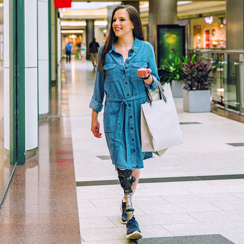 A female user is wearing shopping bags while walking with her Taleo Vertical Shock foot.