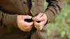 A man buttons his brown jacket using an Ottobock partial hand silicone prosthesis