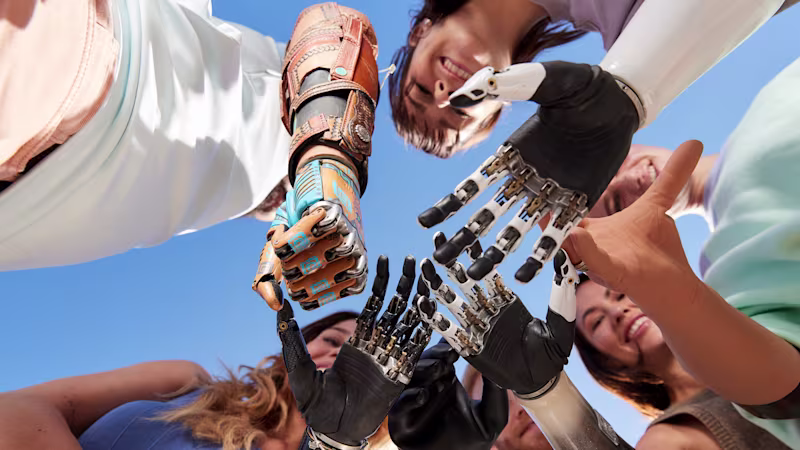 A group of prosthetic hand users standing in a circle placing their prosthetic hands including the bebionic from Ottobock in the middle on top of each other.