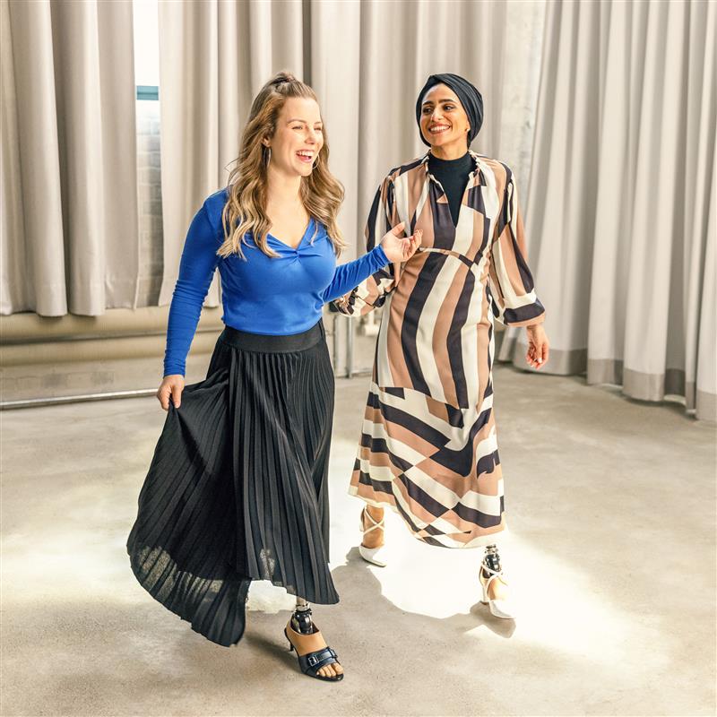 Two female users are laughing and walking with their Taleo Adjust prosthetic foot.