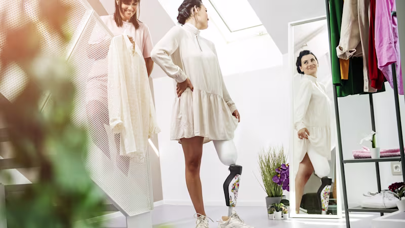 Rebecca poses in a dress in a boutique with her customized Ottobock-manufactured C-Leg 4