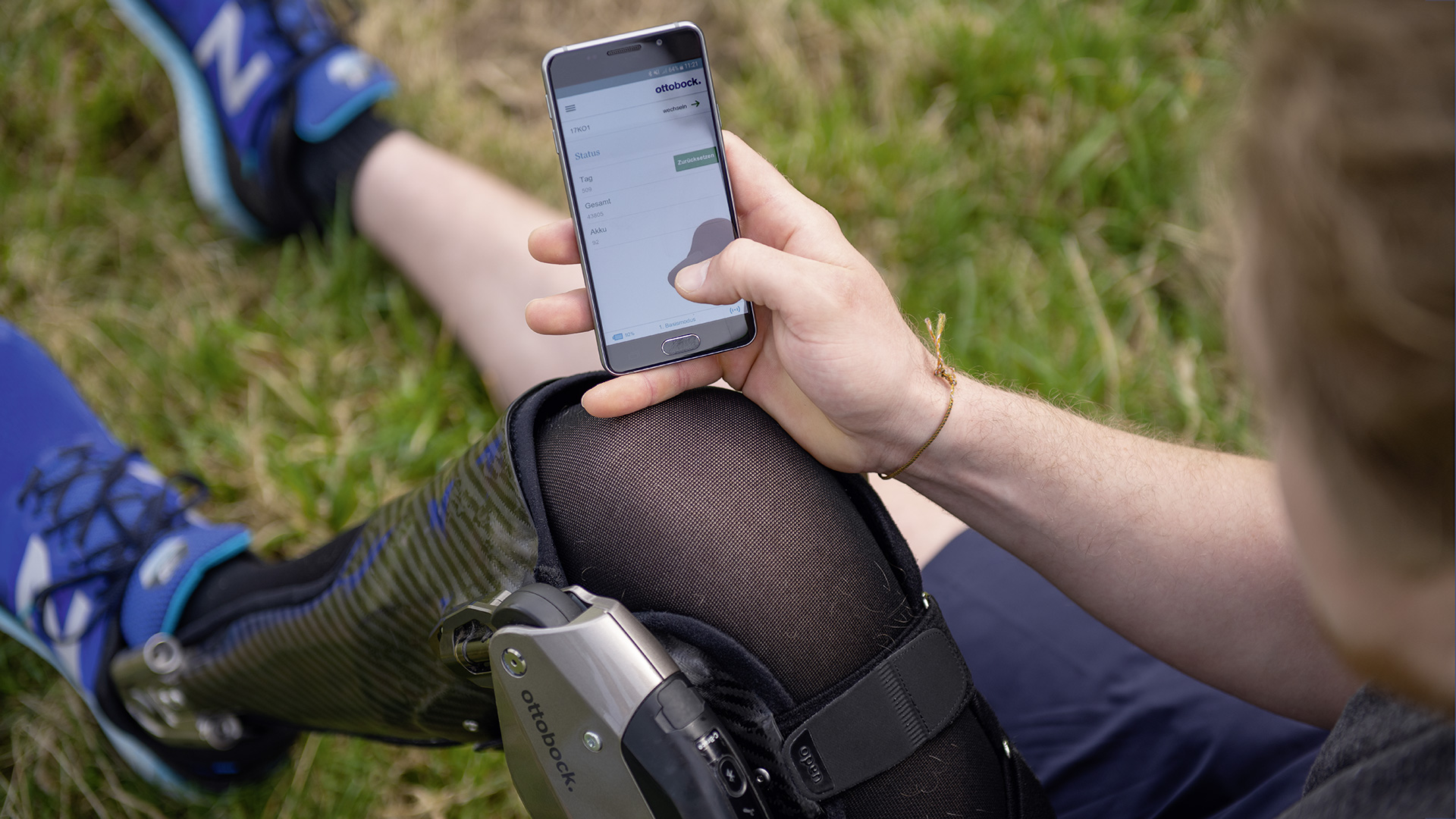 A C-Brace wearer uses their phone to access the Cockpit app to control their orthosis