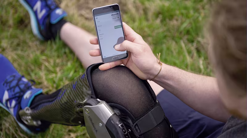 A C-Brace wearer uses their phone to access the Cockpit app to control their orthosis
