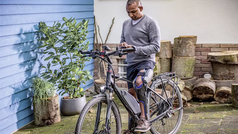 A C-Brace wearer uses their phone to access the Cockpit app to control their orthosis