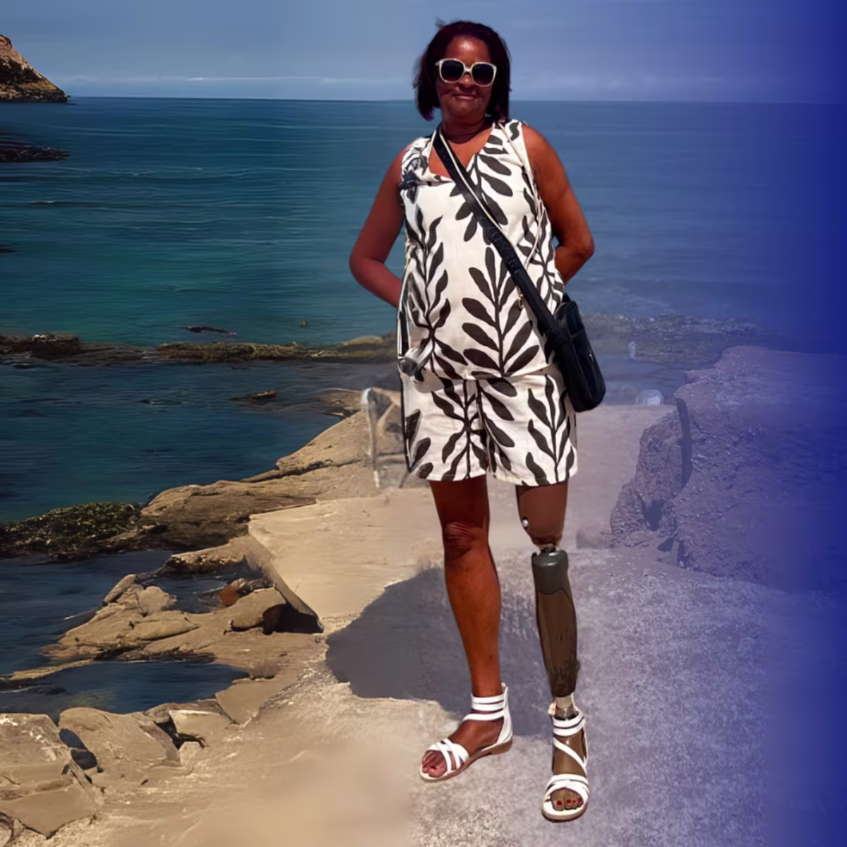 Taleo Adjust prosthetic foot user Carole standing on rocks with the ocean behind her.