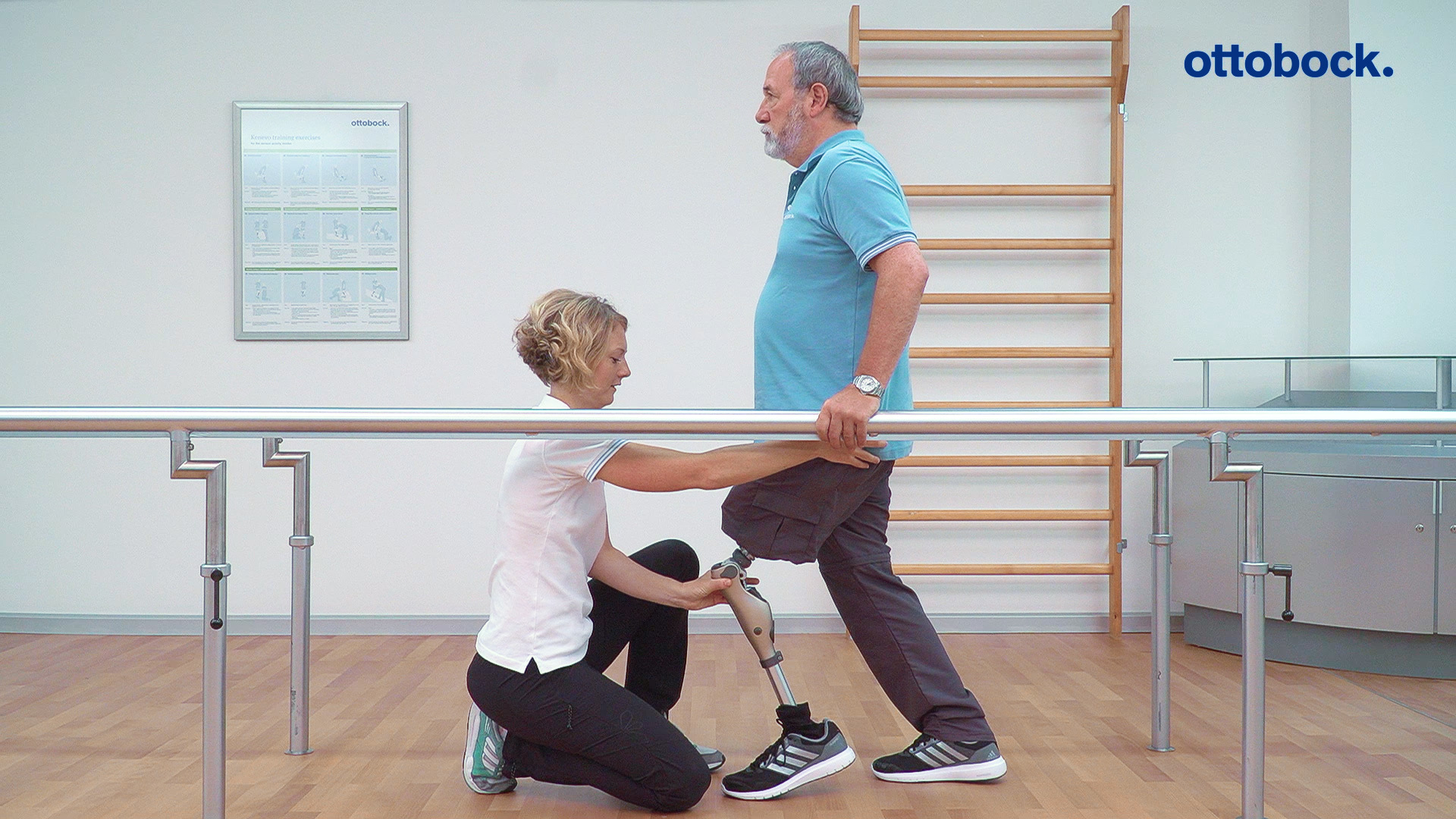 Специалист по реабилитации занимается с пользователем протеза в брусьях.
