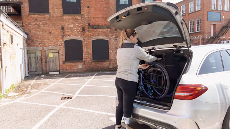 Hannah Moore, Ottobock Avantgarde hafif manuel tekerlekli sandalyesini bir arabanın bagajına koyuyor.